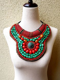 "Stunning handmade Tibetan bib collar necklace in faux teal green turquoise, coral and amber beads, with a stunning central brass medallion. Perfect with a flowing caftan or an itsy black bikini. Perfect anywhere you are barefoot! Wear your hair up, with a bright ribbon or turban, or wear it down! You don't need much else! Eye-catching geometric pattern with a mix of smooth and textured beads. This is a handmade reproduction of a Tibetan tribal neck piece or Skeypuk, which is worn as collars on Latest Embroidery Designs, Beaded Crossbody Bag, Bib Collar, Necklace Collar, Necklace Chunky, Bib Necklaces, Amber Beads, Neck Piece, Necklace Boho