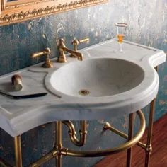 a bathroom sink sitting under a mirror next to a wall mounted faucet with a toothbrush on it