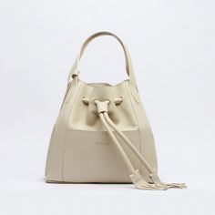 Timeless Beige Shoulder Bag With Handle Drop, Cream Bucket Bag With Handle Drop, Timeless Beige Double Handle Satchel, Cream Bucket Satchel With Detachable Strap, Timeless Beige Textured Leather Shoulder Bag, Beige Leather Bucket Satchel, Beige Textured Leather Bucket Bag, Cream Leather Bucket Satchel, Beige Textured Leather Shoulder Bag For Evening