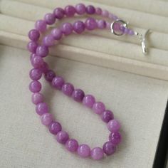 Embrace the essence of spring and summer with our Lavender Grapevine Gemstone Beaded Necklace! The enchanting purple hue exudes a blend of dreaminess and a hint of mystery. Crafted with romantic healing lavender gemstones delicately strung together, complemented by a minimalist OT clasp, this necklace embodies gentle elegance with a touch of individuality. Perfectly versatile, it effortlessly elevates any ensemble, whether paired with a solid-colored tee or a breezy resort sundress, exuding a charming Southern French allure. Metal: Recycled Sterling Silver Plated On Brass Gemstone: Natural Stone 10mm Length: 480mm Weight: 60g Lavender Gemstone Beaded Necklaces As Gift, Lavender Gemstone Beaded Necklaces For Gift, Lavender Gemstone Beads Necklace For Gift, Elegant Lavender Necklaces With Natural Stones, Lavender Crystal Necklaces With Natural Stones For Gift, Handmade Lavender Crystal Necklaces With Round Beads, Elegant Crystal Healing Necklaces With Round Beads, Elegant Amethyst Beaded Necklaces For Healing, Elegant Round Beads Crystal Necklace For Healing