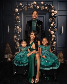 the family is posing for a photo in front of a christmas wreath with ornaments on it