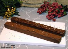 a piece of chocolate cake sitting on top of a white cutting board next to berries