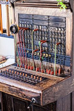 an old wooden machine with many different types of knobs and wires on it's side