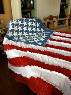 an american flag made out of red, white and blue blankets on a bed in a living room