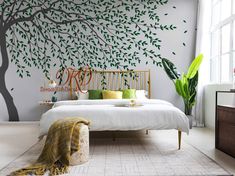 a bedroom with a tree painted on the wall and a bed in front of it