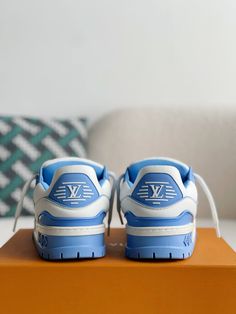 Step into a world of effortless cool with these LV Trainer Maxi-inspired sneakers in a refreshing white and blue colorway. These statement shoes, inspired by Louis Vuitton's bold design, feature an exaggerated silhouette and eye-catching accents, creating a playful and fashion-forward look. Crafted with meticulous attention to detail, these sneakers offer a premium blend of comfort and luxury, perfect for those who dare to stand out. Your order arrives in a branded shoe box with dust bags, extra Modern Blue Sneakers With Contrast Sole, Designer Sneakers With Cushioned Footbed For Streetwear, Luxury Blue Sneakers With Rubber Sole, Designer Blue Low-top Sneakers, Modern Blue High-top Sneakers With Cushioned Footbed, Luxury Blue Sneakers With Contrast Sole, Luxury Blue Sneakers For Streetwear, Designer Blue High-top Sneakers, Fall Winter Jacket