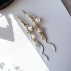 "\"Discover the elegance and beauty of nature with these enchanting Lily of the Valley drop earrings. Featuring a swirling threader design adorned with delicate beads of lily of the valley flowers, these earrings are a true testament to the allure of the natural world. Handcrafted to perfection, these earrings are a must-have for anyone who appreciates unique, nature-inspired accessories. 🌸 Exquisite Lily of the Valley Design: These drop earrings showcase the elegance of Lily of the Valley flowers, with intricate beaded detailing that brings the essence of nature to your style. Each flower is carefully crafted to create a captivating and unique visual experience. 🌀 Swirling Threader Style: The swirling-shaped threader design adds a touch of contemporary flair to these earrings, providing Whimsical Flower-shaped Wedding Jewelry, Elegant Adjustable Flower Earrings, Graceful Dangle Bridal Earrings For Gift, Elegant Wedding Threader Earrings, Elegant Wire Wrapped Threader Earrings, Delicate Dangle Flower Earrings For Bridesmaids, Elegant Flower Earrings For Mother's Day, Nature-inspired Dangle Earrings For Weddings, Delicate White Threader Earrings For Gift