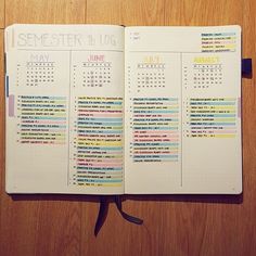 an open planner book on a wooden table with the pages marked in different colors and numbers