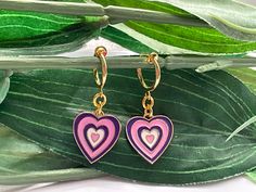 Pretty little earrings! For those that want to wear hoops but do not have pierced ears! Perfect These are made with a gold tone spring clip on hoops (13mm) with gold tone purple/pink hearts (12mm) attached  This is a set of 2 hoops More Gold hoop Clips https://www.etsy.com/uk/listing/704679868/pearl-hoop-dangle-clip-on-earrings-girls?ref=shop_home_active_68&sca=1 ESTIMATED DELIVERY TIMES SHIPPING FROM UK: UK: Royal Mail First Class:  1-3 business day Canada: Royal Mail Standard International Shipping:  7-30 business days North America: Royal Mail Standard International Shipping:  7-21 business days Europe: Royal Mail Standard Shipping:   3-10 business days Australia, New Zealand and Oceania: Royal Mail Standard International Shipping:  7-31 business days May vary during busy periods Once y Pink Hoop Earrings For Valentine's Day, Cute Pink Hoop Earrings For Valentine's Day, Pink Drop Huggie Earrings, Pink Heart Huggie Earrings For Valentine's Day, Pink Huggie Heart Earrings For Valentine's Day, Pink Heart Huggie Earrings For Pierced Ears, Trendy Small Hoop Heart Earrings As Gift, Pink Huggie Heart Earrings For Pierced Ears, Cute Pink Huggie Jewelry