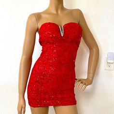 a mannequin wearing a red dress with sequins on it