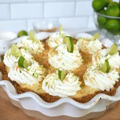 a pie with limes and whipped cream on top