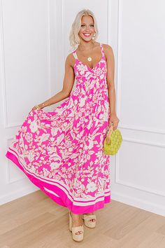 - Showcase sunny style with this stunning floral maxi dress! Embrace the essence of casual elegance as you sway in its flowy silhouette and enchant with a flirty open back. Perfect for stylish strolls downtown, or any summer adventure, this dress is a must-have addition to your wardrobe rotation. Let the fabulous blooms and effortless charm brighten up your day wherever you go! - Lightweight material with an abstract floral print - A built-in lining ending above the knee - A v-cut neckline - Gat Feminine Flowy Maxi Dress For The Beach, Feminine Maxi Dress For Beach Season, Pink Floral Print Maxi Dress For Beach Season, Feminine Pink Maxi Dress For Beach Season, Pink Floral Print Maxi Dress For Summer, Pink Maxi Dress For Garden Party And Beach Season, Breezy Floral Print Maxi Dress, Flowy Maxi Dress For Garden Party And Beach Season, Pink Sleeveless Dresses For Summer Outings