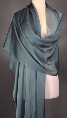 This scarf is iridescent elegance and is definitely a muted blue. Monitor may reflect the scarf brighter than what it actually is.  Perfect for all seasons.  Dress it up or dress it down.  The choice is yours.  All of my scarves can be dressed up or down. I finish my scarves with a machine rolled hem.  I am constantly looking for unusual fabrics that would make wonderful scarves. Be nice to your scarves and they will last a long, long time. Enjoy the scarf and wear it with confidence.  Polyester Elegant Blue Scarves For Wedding, Elegant Blue Scarf For Wedding, Elegant Blue Shawl Scarves, Elegant Blue Silk Shawl Scarf, Elegant Blue Silk Scarf For Formal Occasions, Elegant Blue Silk Scarf For Wedding, Elegant Silk Scarf For Party, Elegant Blue Silk Scarf For Evening, Elegant Blue Scarves For Party