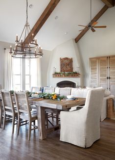 a dining room table with chairs and a chandelier hanging from it's ceiling