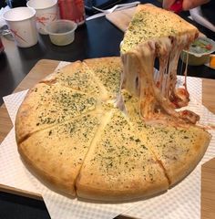 a large pizza sitting on top of a cutting board covered in cheese and toppings