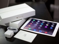 an apple ipad is sitting on a table with its box and charger next to it