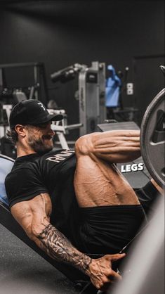 a man laying on top of a bench in a gym