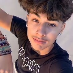 a young man wearing bracelets and a black shirt