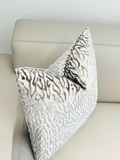 a white couch with a black and white pillow on it's backrests