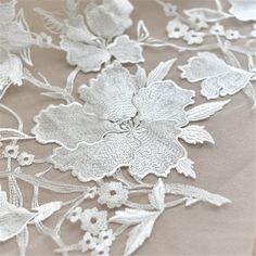 an embroidered fabric with flowers and leaves on it