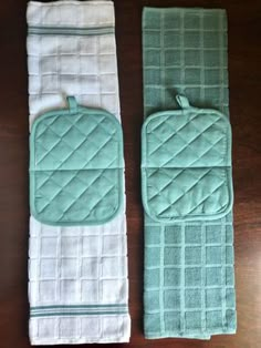 two green and white towels sitting on top of a wooden table