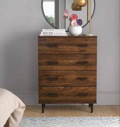 a bedroom with a bed, dresser and mirror on the wall in front of it