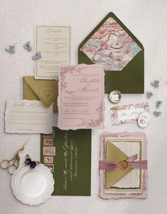 the wedding stationery is laid out on top of each other, including cards and envelopes