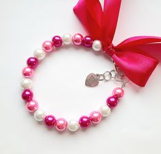 a pink and white bracelet with a heart charm