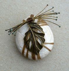 a brooch that is sitting on top of a rock