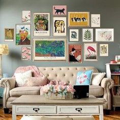 a living room filled with furniture and lots of pictures on the wall above it's coffee table