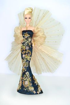 a barbie doll dressed in a black and gold gown with an elaborate fan behind her head