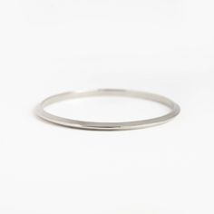 This triangular-shaped wire makes a beautiful "knife-edge" bangle. This subtle pointed shape adds dimension and shine. A 4mm x 3.5mm solid 14k gold bangle. Everyday White Gold Bangle, Everyday Stackable White Gold Bangle, Minimalist Stackable White Gold Bangle, Stackable White Gold Bangle For Everyday, Modern Stackable Round Bangle, Minimalist Stackable Hoop Bangle, Minimalist Stackable Bracelets With Round Band, Minimalist Stackable Round Band Bracelets, Minimalist Stackable Round Bangle