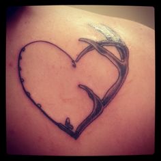 a heart shaped tattoo on the back of a woman's shoulder