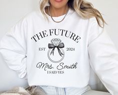 Did you recently get engaged?  This custom FUTURE MRS Gildan 18000 sweatshirt is the perfect way to show your excitement for your newly engaged status.  The addition of your future last name makes this sweater extra special.  Buy for yourself or make this an engagement gift, bridal shower gift, or gift for the newly engaged bride-to-be. PLEASE READ THROUGH ALL OF THE FOLLOWING INFORMATION.  IF YOU HAVE FURTHER QUESTIONS, WE ARE HAPPY TO HELP! Welcome to CuratedClothCo.!  Here you can find the pe Long Sleeve Cotton Sweatshirt For Anniversary, Newly Engaged Gift, Engagement Gifts Newly Engaged, Mrs Sweatshirt, Get Engaged, Screen Printing Techniques, Personalized Bride, Future Mrs, Newly Engaged