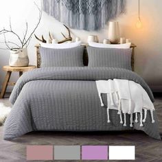 a bed with grey and white bedspread in a room