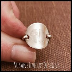 "This ring is made with a round disc engraved with your choice of 1 or 3 letter monogram and shaped to resemble a saddle style ring. Wire has been added to make up the band of the ring and the edge of disc has been hammered to add a neat texture. This ring is super comfortable to wear and I love mine! I can make this ring with rose gold filled, sterling silver (shown), or yellow gold filled components. You can also choose your disc size (5/8\" or 3/4\") and font preference. Use the options pull 3 Letter Monogram, Saddle Ring, Ring Wire, 3 Letter, Letter Monogram, Jewelry Personalized, Custom Ring, Initial Jewelry, Personalized Initials