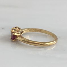 Details: Lovely Mid Century 18K yellow gold diamond and ruby ring, with two rubies and a diamond. Please ask all necessary questions prior to placing an order. Measurements: The size is 5 3/4 US and can be sized for a fee. Condition: The overall all condition of this ring is very good. Heirloom Amethyst Ring With Diamond In Gold, Heirloom Gold Amethyst Ring With Diamond, Classic Three Stone Ruby Ring With Diamonds, Gold Diamond Ring With Pink Sapphire For Wedding, Gold Pink Sapphire Diamond Wedding Ring, Hallmarked Yellow Gold Ruby Ring For Wedding, Yellow Gold Hallmarked Ruby Ring For Wedding, Classic Red Ruby Ring With Single Cut Diamonds, Heirloom Gold Ruby Ring With Rose Cut Diamonds