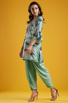 Editor's Note This set features a short tunic with tulip dhoti pants. Color: Aqua Fabric: Dola Silk; Crepe Silk Care: Dry Clean Only About the Designer Aayushi Maniar label was founded in the year 2016. The brand defines luxury with comfort and modern design philosophy. Her styles comprise fashion-forward statement pieces like Cape tops, Pre draped sarees, Lehengas and Anarkalis. The aim is to keep traditional aspects with a fresh and renewed perspective that is perfect for a modern woman, a new Tulip Dhoti, Draped Sarees, Cape Tops, Short Tunic, Aqua Fabric, Dhoti Pants, Drape Saree, Color Aqua, Silk Crepe