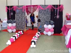 a party with pink and black decorations on the floor