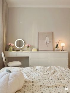 a bedroom with a white bed, dresser and mirror in it's center area