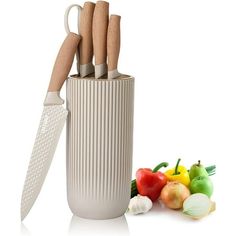 a knife and some vegetables on a white surface with a fork in the holder next to it