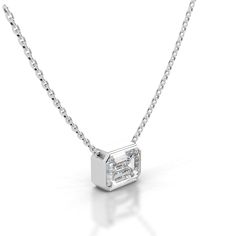 a white diamond necklace on a chain with a small square cut stone in the center