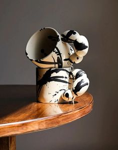 two vases sitting on top of a wooden table next to each other with black and white designs