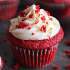 red velvet cupcakes with white frosting and sprinkles