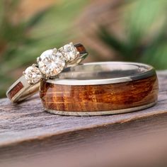 two wedding rings sitting on top of a wooden table