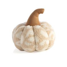 a stuffed pumpkin sitting on top of a white surface