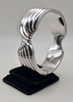 Here is the beautiful designed of 925 Sterling Silver Wide Ribbed Knot Hinged Bangle made by ITALY.  Good pre-own condition and Stamped " 925 ITALY" maker mark inside the bangle. Bangle inner circumference: 6.75" (17 cm)  ;  Inner diameter: 2 5/16" (5.9 cm) Bangle wide: 3/4" (1.9 cm) Weight: 37 grams (1.2 Troy Ozs )  Please carefully review the item description and accompanying pictures before making a purchase, as we do not offer a return or exchange policy. If you have any questions or require assistance, please do not hesitate to reach out to us.  Check my store link to find more treasures:   https://galaxysilvercity.etsy.com Silver Hinged Bangle As Gift, Silver Hinged Bangle For Anniversary, Anniversary Silver Hinged Bangle, Silver Bangle With Shiny Finish, Silver Oyster Bangle, Silver Hallmarked Cuff Bracelet, Hinged Sterling Silver Bangle In Silver, Hallmarked Silver Metal Bangle, Shiny Sterling Silver Bangle