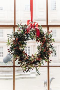 a christmas wreath hanging on a window sill