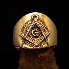 This stunning Master Mason Blue Lodge Ring in gold shiny brass is crafted from solid brass and measures 19 mm along the finger. It exudes elegance and sophistication, making it the perfect accessory for any masonic member. We ship worldwide to 185 countries! Please allow 1-2 business weeks for your order to arrive. Adjustable Gold Brass Signet Ring, Adjustable Yellow Gold Brass Signet Ring, Ceremonial Adjustable Gold Engraved Ring, Adjustable Gold Engraved Ring For Formal Occasions, Ceremonial Gold Signet Ring Symbolic Style, Gold Ceremonial Symbolic Signet Ring, Symbolic Gold Signet Ring For Ceremonial Occasions, Symbolic Gold Signet Ring For Ceremonial Use, Gold Brass Signet Ring With Symbolic Style