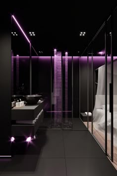 a black bathroom with purple lighting in the shower and sink area next to each other